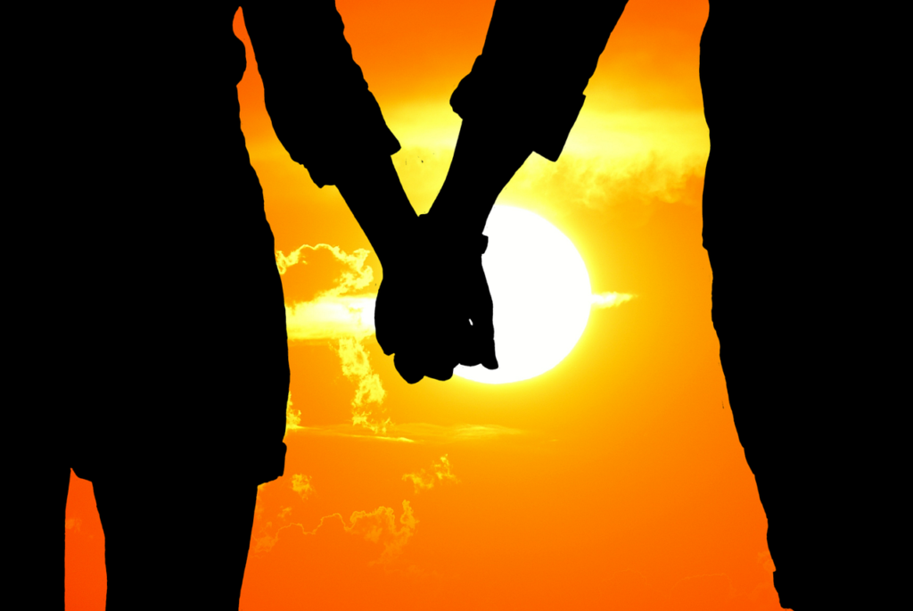 Romantic couple holding hands while watching a beautiful sunset in Munnar